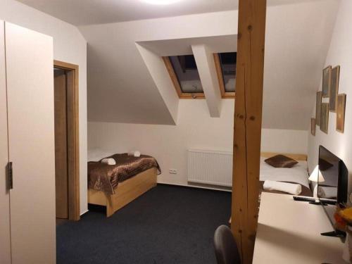 a small room with a bed and a desk at Penzion a Restaurace u Sousedů in Strážný