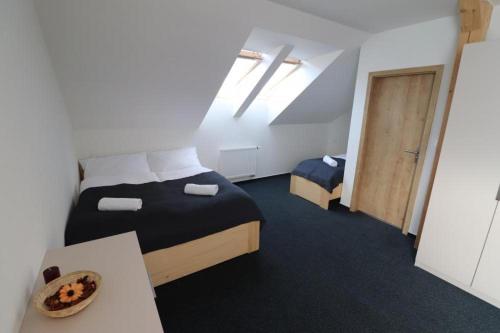 a bedroom with a bed and a table and a door at Penzion a Restaurace u Sousedů in Strážný