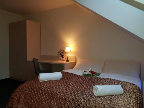 a bedroom with a bed and a desk with a lamp at Penzion a Restaurace u Sousedů in Strážný