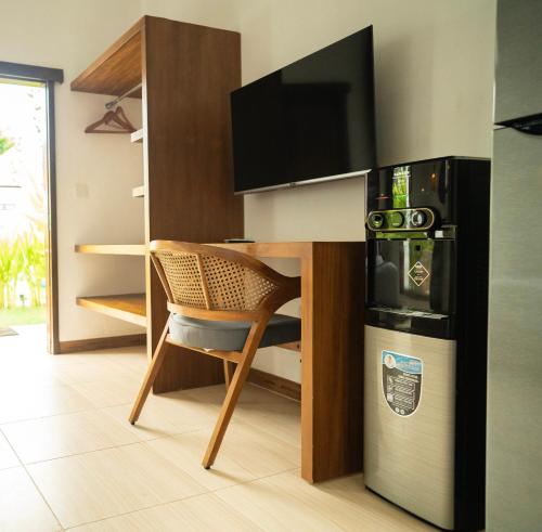a kitchen with a table with a chair and a refrigerator at Nomada Villas in Kuta Lombok