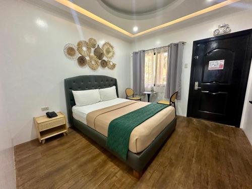 a bedroom with a large bed with a green blanket at 3 Peaks Resort & Boutique Hotel in Lipa