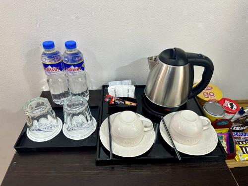 a tray with cups and plates and water bottles at 3 Peaks Resort & Boutique Hotel in Lipa