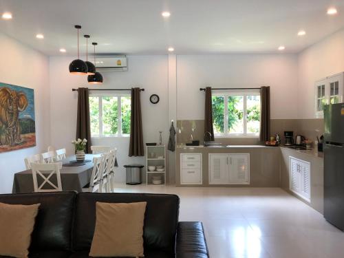 a living room with a couch and a kitchen at Kongsai Private poolvilla in Klong Khong in Ko Lanta Yai