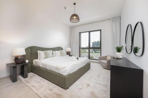 a white bedroom with a large bed and a desk at Free housekeeping visits during your stay - StayShort - Warm and Earthy 1-Bedroom Apartment Perfect for Family in Madinat Jumeirah Living! in Dubai