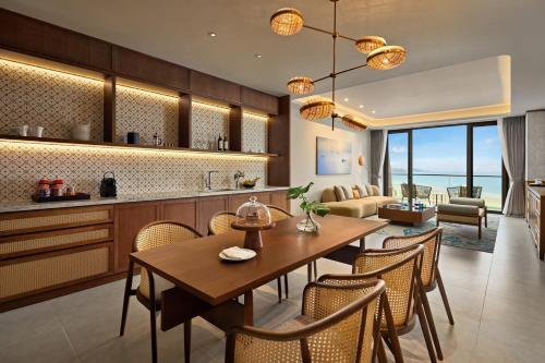 a kitchen and dining room with a table and chairs at Angsana Quan Lan, Ha Long Bay in Quan Lạn