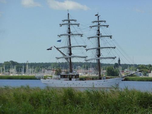 a tall ship sitting on the water in a harbor at Halbinsel Resort Peenemünde in Peenemünde