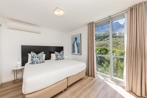a bedroom with a large bed and a large window at The Crystal Apartments in Cape Town