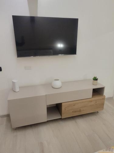 a living room with a tv on a white wall at Casa Grazia in Domodossola
