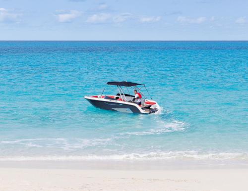 a man in a boat in the water on the beach at Miyakojima Kurima Resort Seawood Hotel in Miyako Island