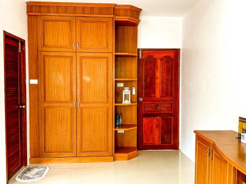 a kitchen with wooden cabinets and a red door at Amara Beach Resort Koh Phangan in Haad Yao
