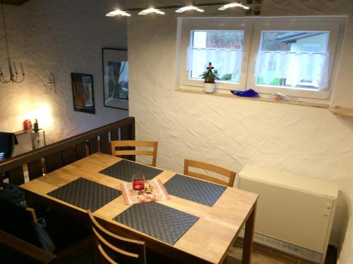 comedor con mesa, sillas y ventana en Ferienhaus Stausee Bitburg en Biersdorf