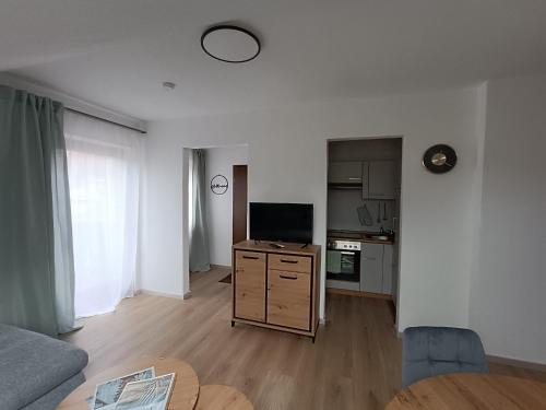 a living room with a couch and a television and a table at Gästehaus am Schlossberg in Friedenfels