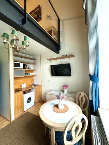 een kleine woonkamer met een tafel en een tv bij Loft Old Town in Tallinn