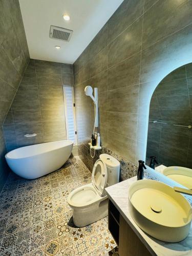 a bathroom with a tub and a toilet and a sink at 朵2包棟Villa in Xiaoliuqiu