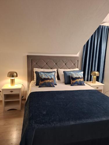une chambre avec un grand lit aux oreillers bleus dans l'établissement Apartments Sonja, à Split