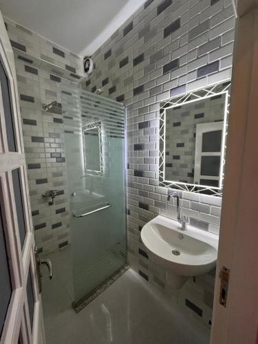 a bathroom with a glass shower and a sink at PiPi NUBIAN HOUSE in Aswan