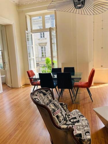 un salon avec une table et des chaises dans l'établissement Magnifique Appartement Bordeaux centre historique, à Bordeaux