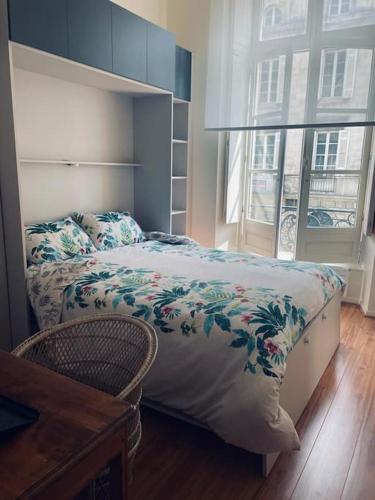 une chambre avec un lit, un bureau et une fenêtre dans l'établissement Magnifique Appartement Bordeaux centre historique, à Bordeaux