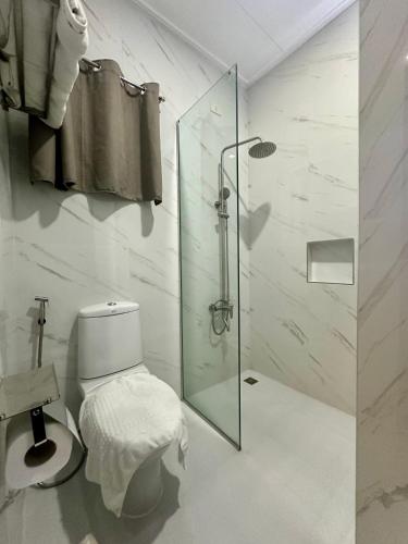 a bathroom with a toilet and a glass shower at 3 Peaks Resort & Boutique Hotel in Lipa