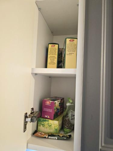 a book shelf with books and boxes on it at Marianne, Apartament 2 Camere, Morii Lake 2 in Bucharest