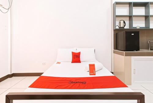 a bed with two red pillows on it in a room at RedDoorz Plus near Tambo Paranaque in Manila