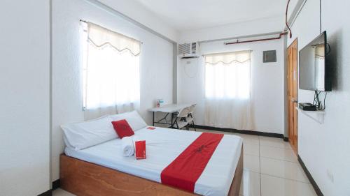 a bedroom with a bed and a tv in it at RedDoorz Plus near Tambo Paranaque in Manila