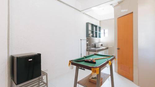 a room with a tv and a table with a pool at RedDoorz Plus near Tambo Paranaque in Manila
