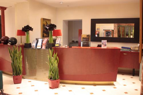 a lobby with a reception desk and potted plants at Hotel Hauteville Opera in Paris