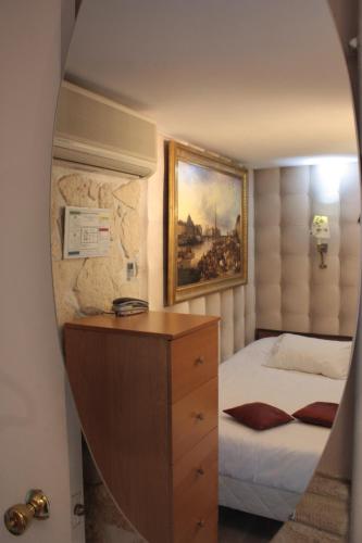 une chambre avec un lit et un miroir dans l'établissement Hotel Hauteville Opera, à Paris
