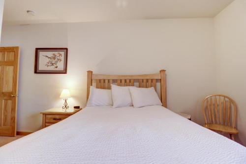 a bedroom with a white bed and a table and chair at 172 Sauterne Sanctuary Townhouse in Silverthorne
