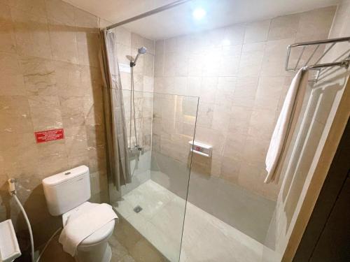 a bathroom with a toilet and a glass shower at The Tandibayang Hotel & Villas in Badung