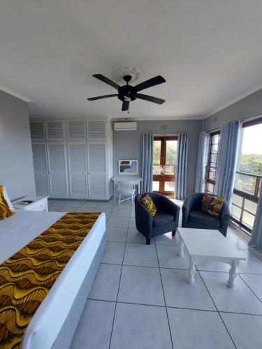 a bedroom with a bed and a ceiling fan at Fairway Guest Lodge in Margate