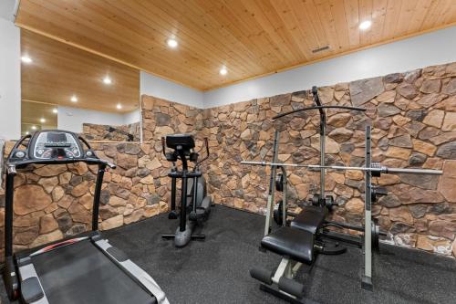 a gym with a stone wall and two tread machines at Luxury Lakeview Retreat - Hot Tub, SUP, Sauna & More! in Carnelian Bay