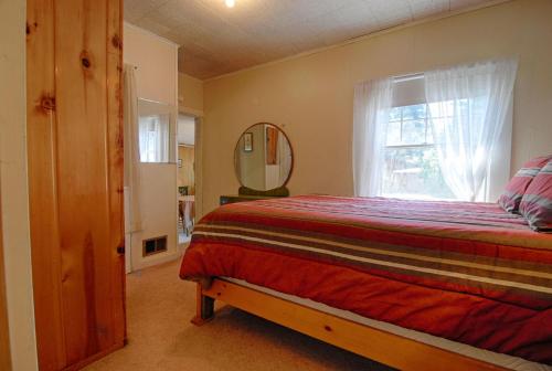 The Jack McCarthy Cabin في تاهو فيستا: غرفة نوم بسرير مع نافذة ومرآة