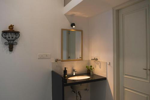 a bathroom with a sink and a mirror at Casa Romana- Indulgent Comfort in Lake and Hill View Rooms in Udaipur