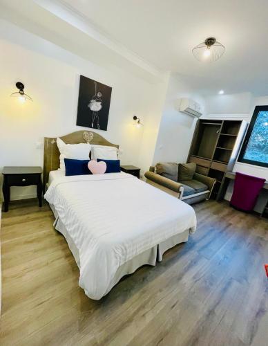 une chambre avec un grand lit blanc et un salon dans l'établissement Paris Dream Villa, à Villejuif