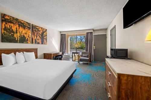 a hotel room with a bed and a television at Days Inn by Wyndham Dubuque in Dubuque