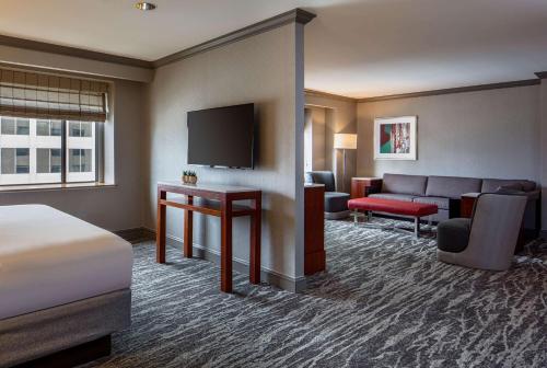 a hotel room with a bed and a couch and a television at Hyatt Regency Saint Louis at The Arch in Saint Louis