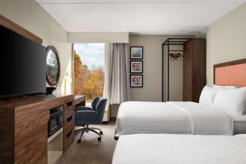 a hotel room with two beds and a television at Hampton Inn Norfolk/Virginia Beach in Virginia Beach
