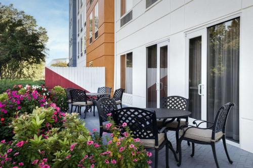 a patio with chairs and tables and flowers on a building at Hilton Garden Inn Tuscaloosa in Tuscaloosa
