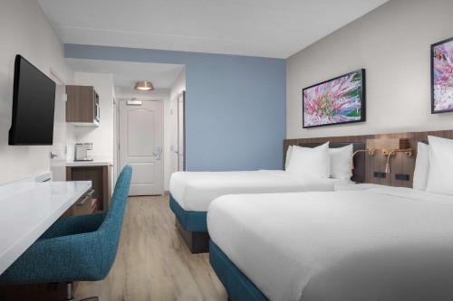 a hotel room with two beds and a desk at Hilton Garden Inn Tuscaloosa in Tuscaloosa