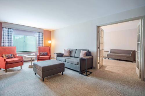 a living room with a couch and two chairs at Hilton Garden Inn Danbury in Danbury