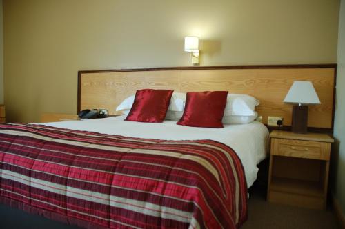 a hotel room with two beds and a lamp at Magherabuoy House Hotel in Portrush