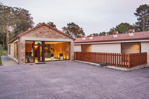 a house with a brick driveway in front of it at Hotel Alén do Mar in Finisterre