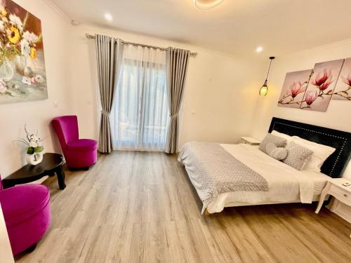 Un dormitorio con una cama y una silla rosa. en Paris Dream Villa, en Villejuif