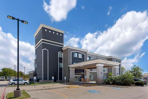 a black building with a car parked in a parking lot at Quality Inn and Suites Groesbeck in Groesbeck