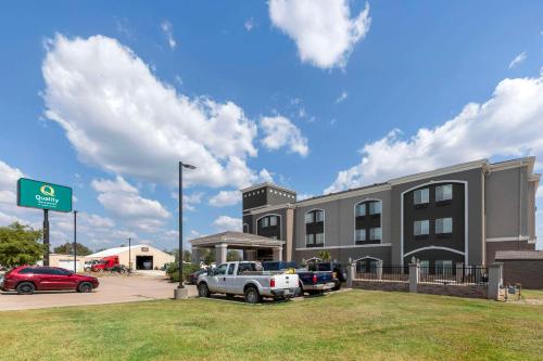 a building with cars parked in front of a parking lot at Quality Inn and Suites Groesbeck in Groesbeck