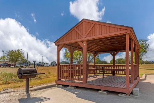 a wooden gazebo with a grill in a park at Quality Inn and Suites Groesbeck in Groesbeck