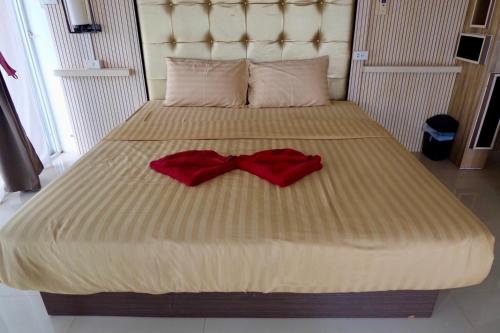 two red bow ties sitting on a bed at The Resort Angel Hill in Ban Khlong Phai