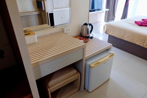 a small room with a bed and a wooden desk at The Resort Angel Hill in Ban Khlong Phai